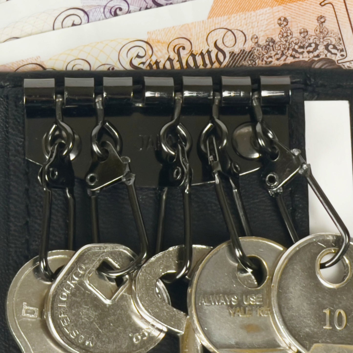 Close-up of the key organizer in a compact black leather wallet featuring sturdy metal hooks