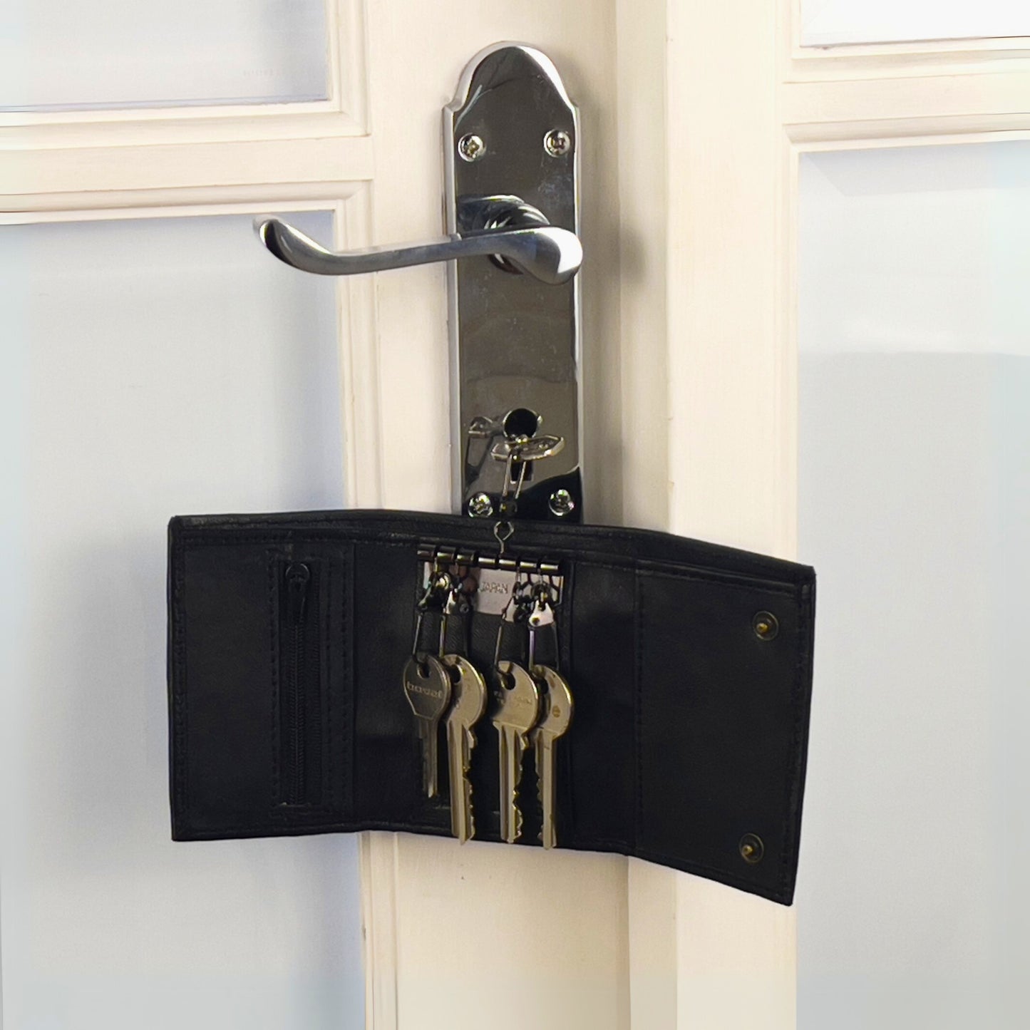 Open black leather wallet showcasing its key hooks, card slots, and zippered pocket