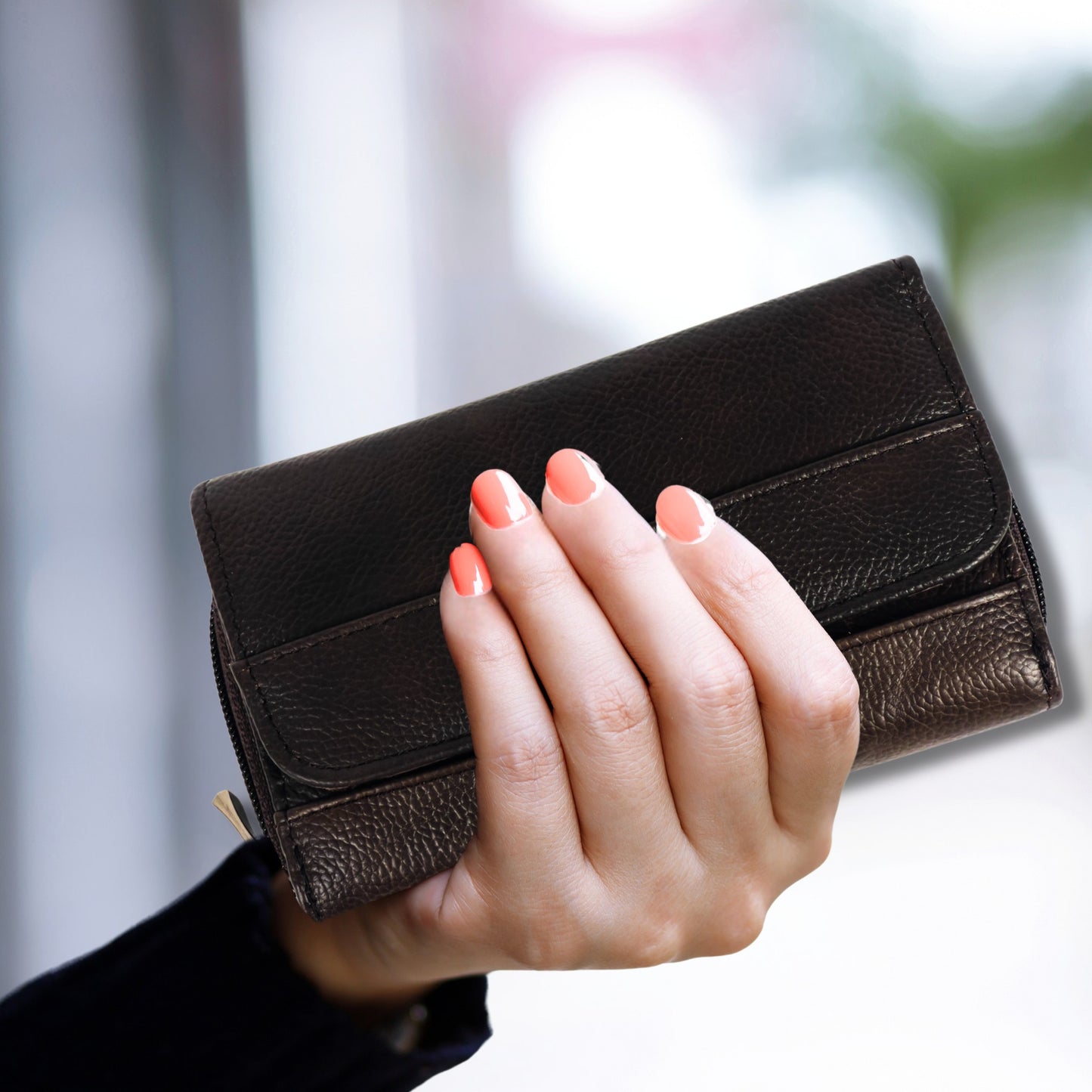 Close-up handheld view of a brown RFID leather wallet with premium texture and elegant compact design, combining security and style.