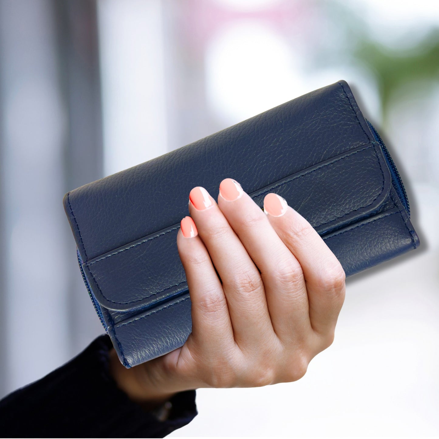 Handheld close-up of a navy RFID leather wallet, highlighting its soft leather finish and stylish design.