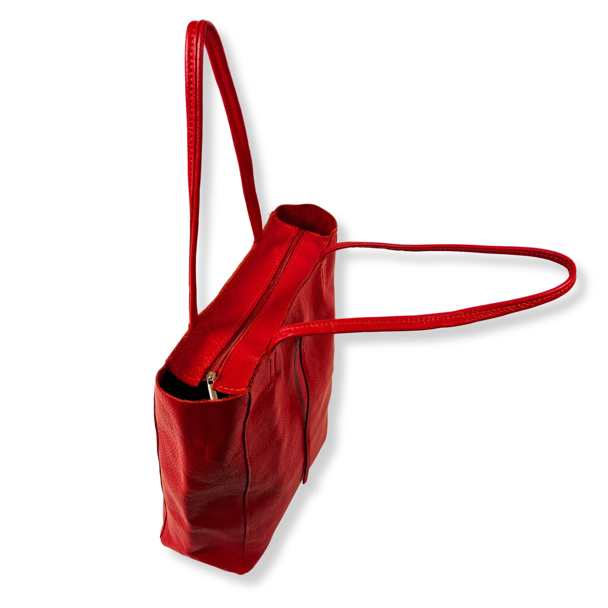 Angled view of red real Italian leather tote bag showing depth and structure.
