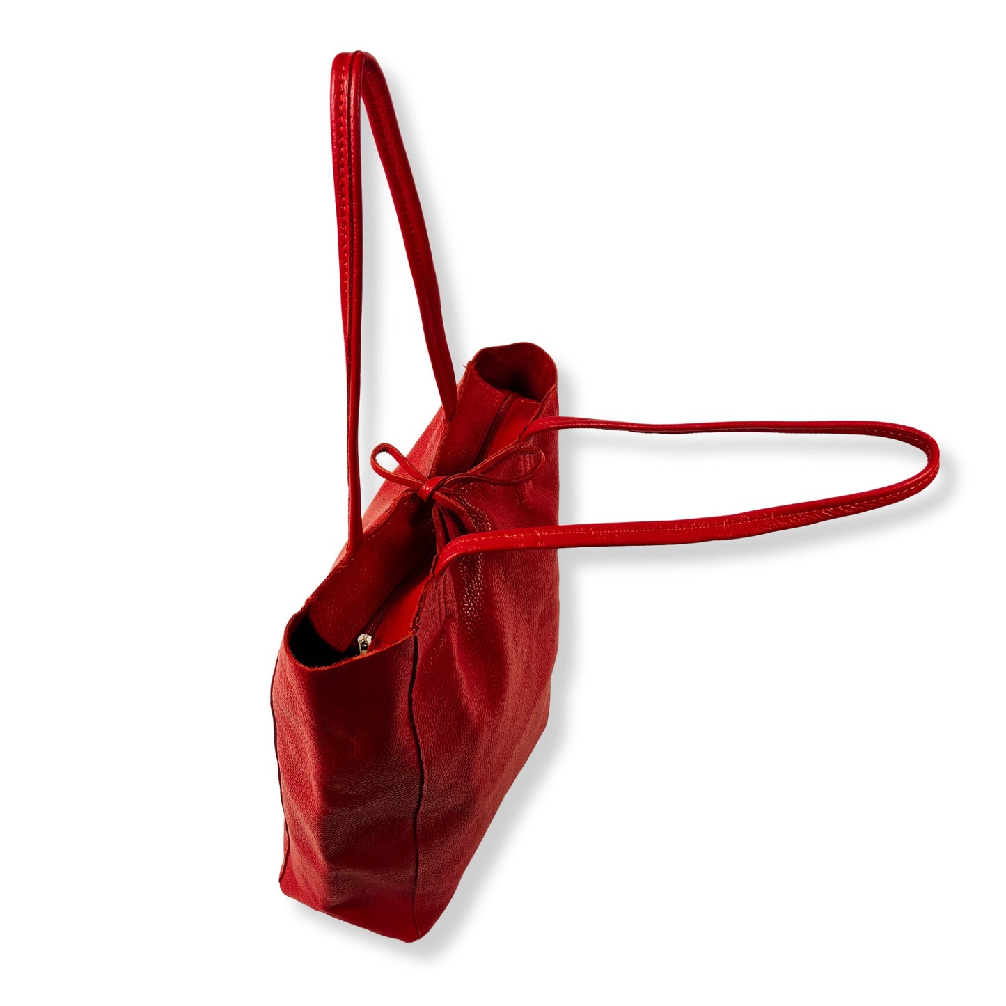 Side view of red real leather tote bag with visible stitching and structure.
