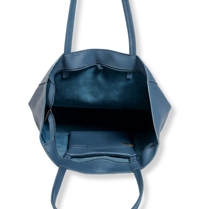 Interior view of denim blue real leather tote bag showing internal zip pocket and unlined craftsmanship.