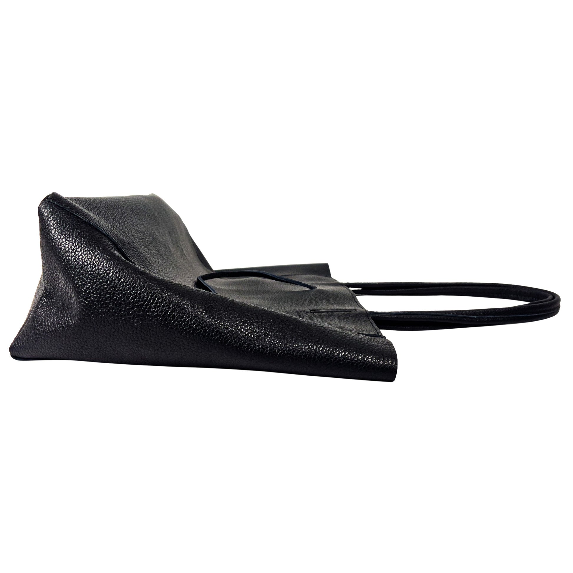 Side profile of black full-grain leather tote bag showing structured seams and depth