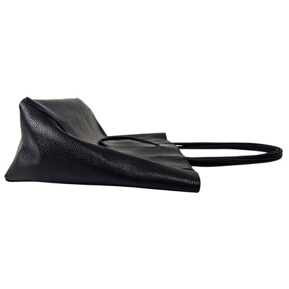 Side profile of black full-grain leather tote bag showing structured seams and depth