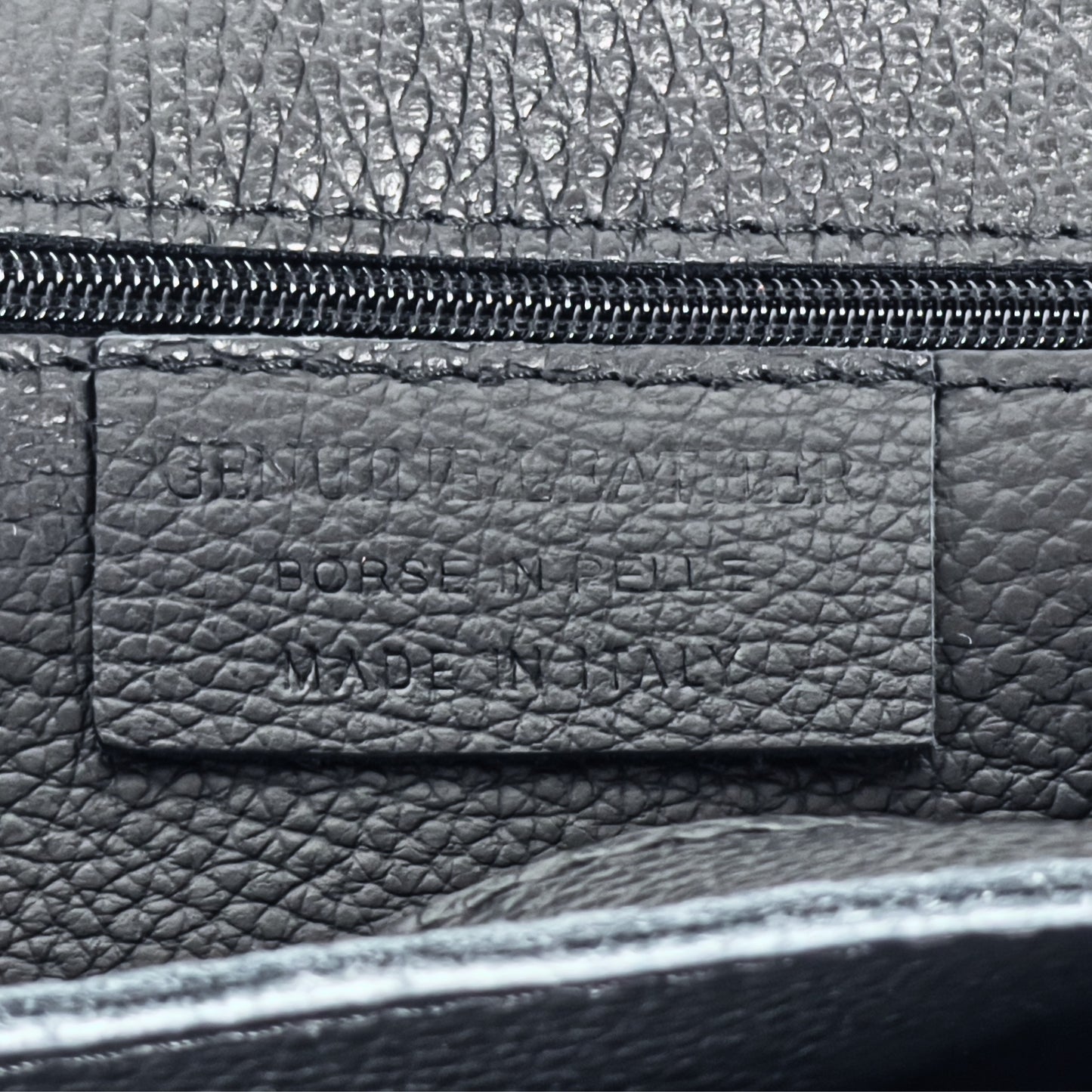 Interior stitching close-up showing functional features of the Black real leather tote.