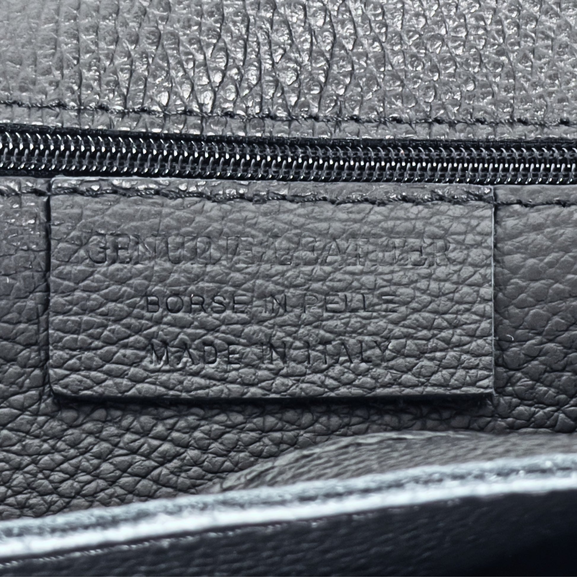 Interior stitching close-up showing functional features of the Black real leather tote.