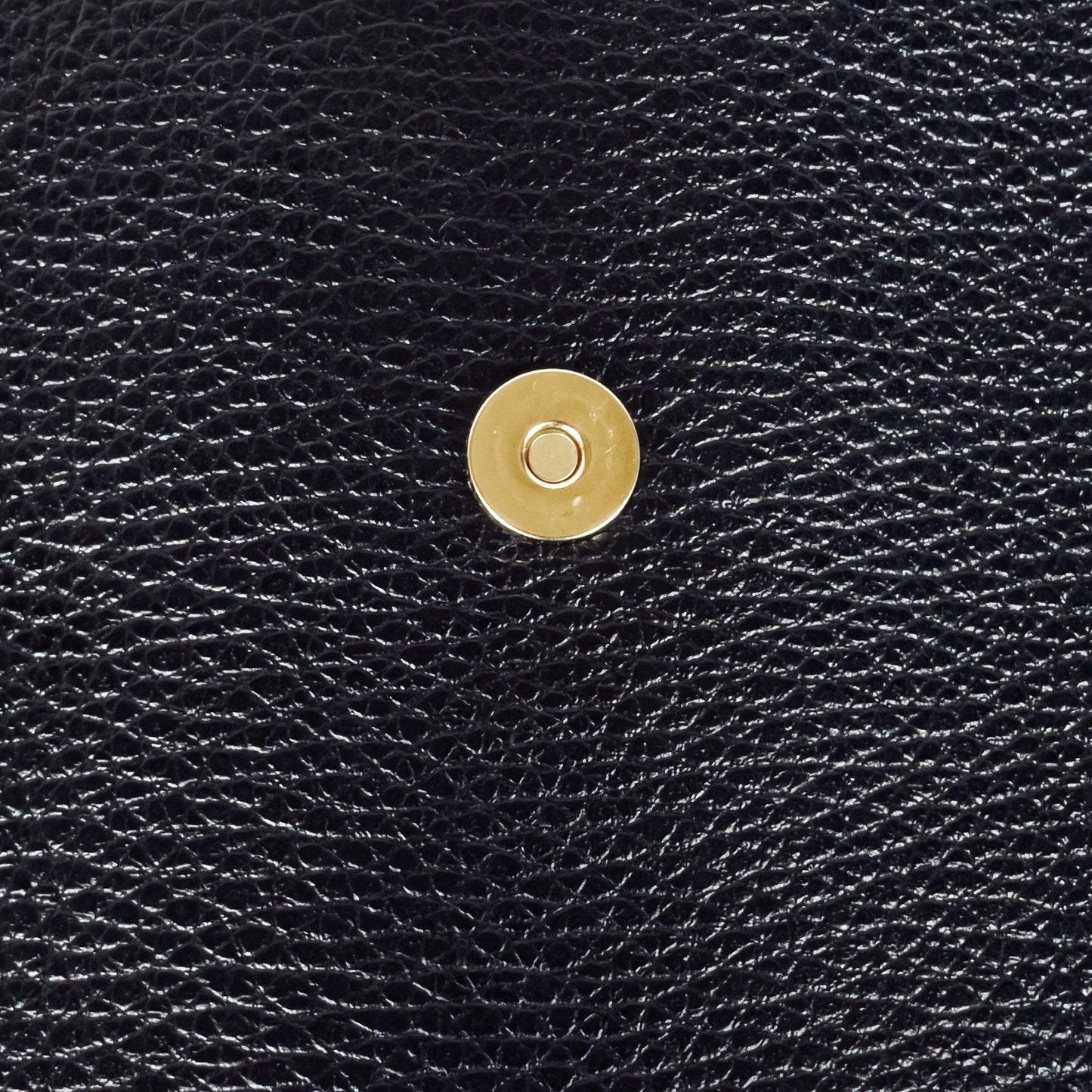 Black real leather phone crossbody bag magnetic clasp detail close up
