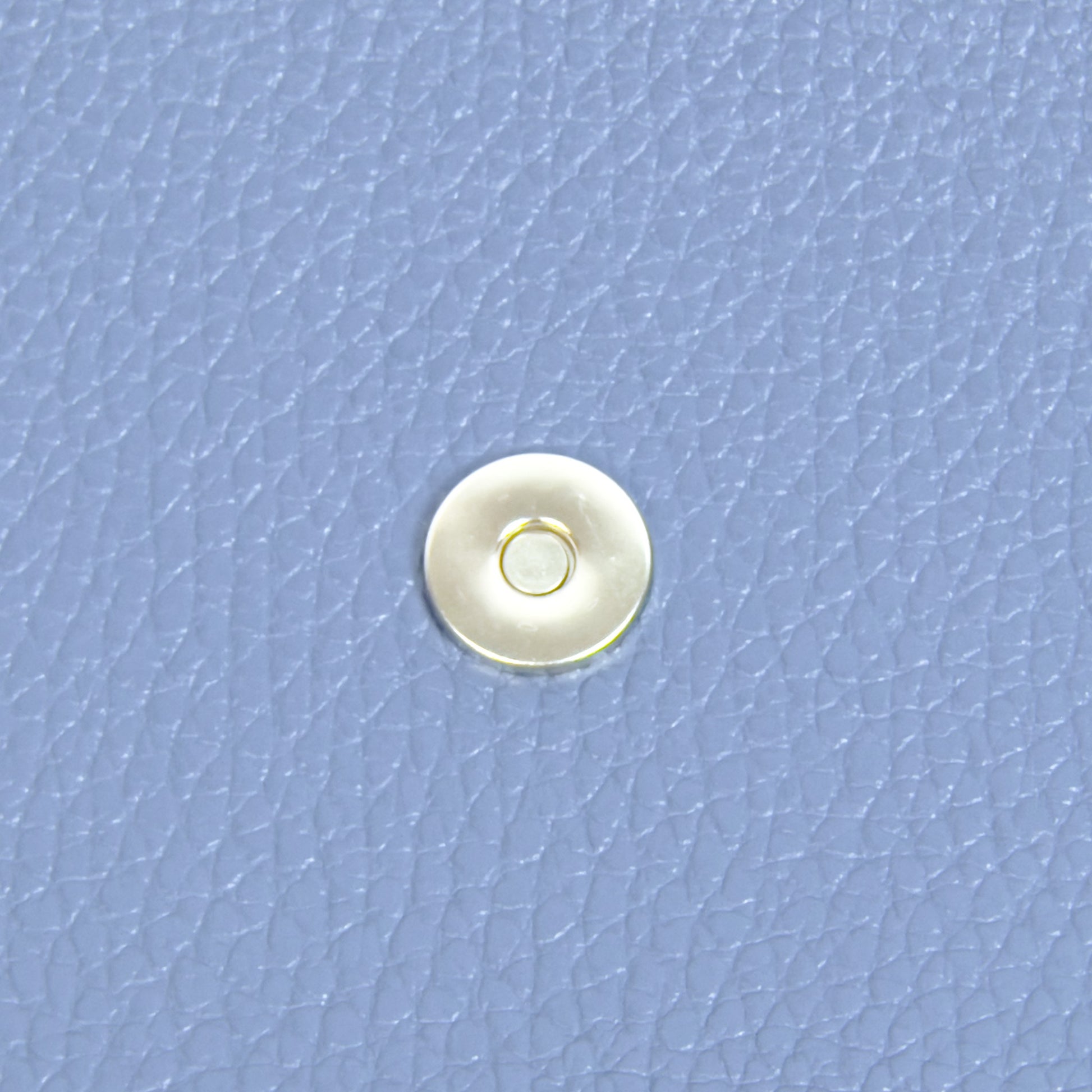 Denim blue leather phone purse magnetic clasp detail close up
