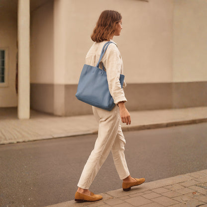Denim blue real leather tote bag lifestyle street scene bag on shoulder real leather denim blue sellertons, showing craftsmanship and detail.