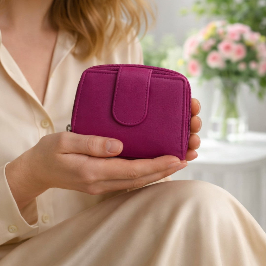 Woman holding a cerise pink soft Nappa leather RFID purse indoors, showing compact size and elegant everyday use