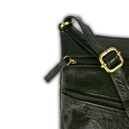 Close-up of the strap detail on a black leather crossbody bag