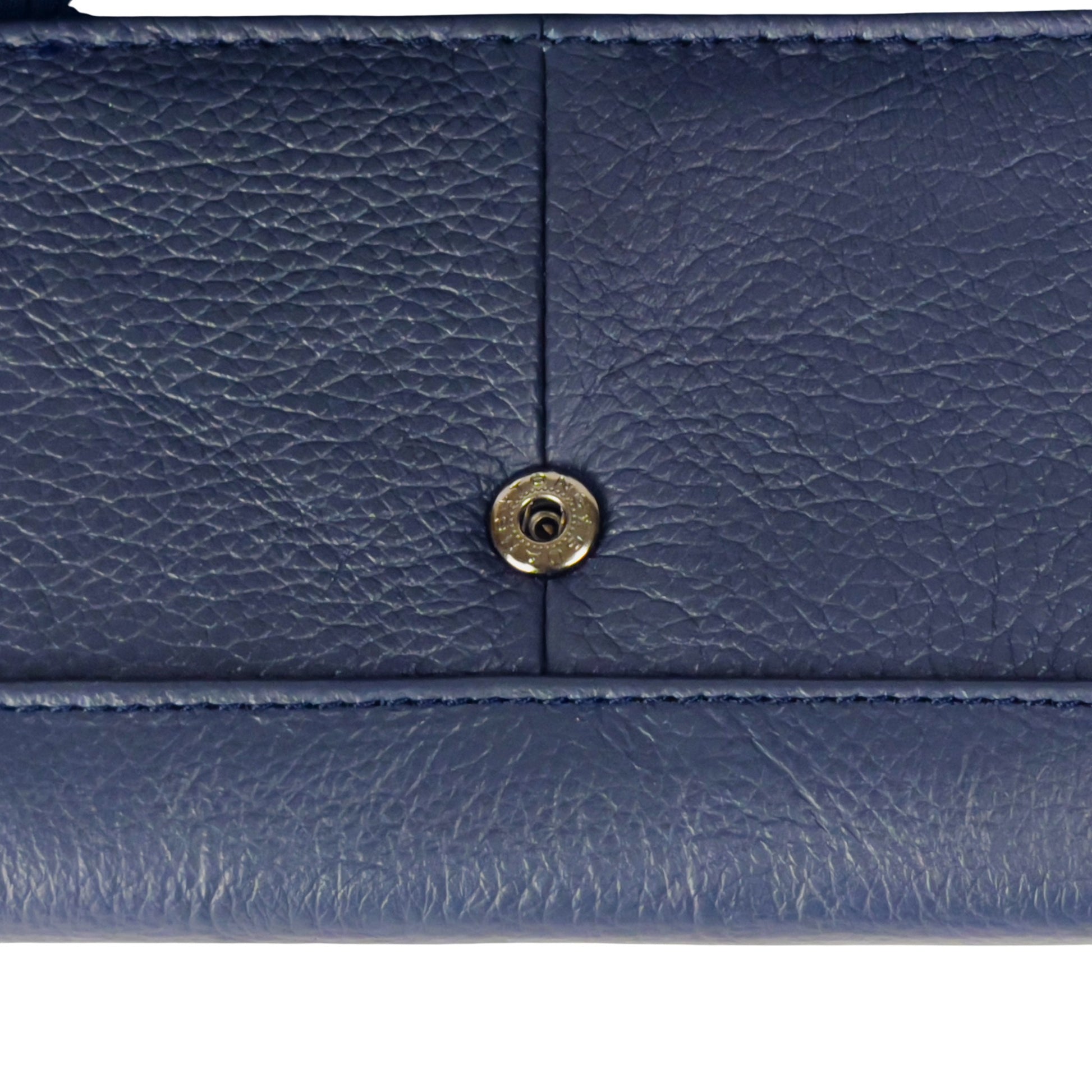 Close-up of the popper detail on a navy RFID leather wallet, emphasizing its secure fastening